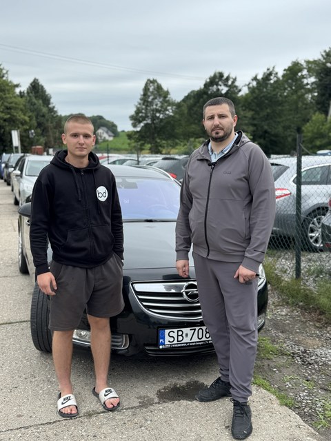 Dwóch klientów przy ciemnym aucie