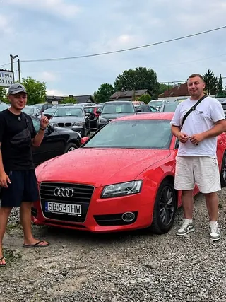 Двоє клієнтів біля червоного Audi