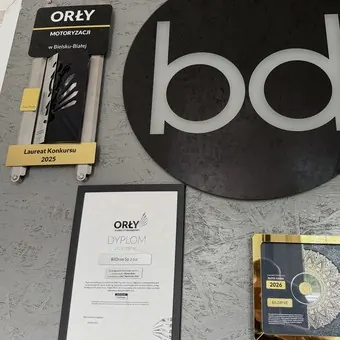 Знак bd і статуетка Orły Motoryzacji на стіні офісу BilDrive